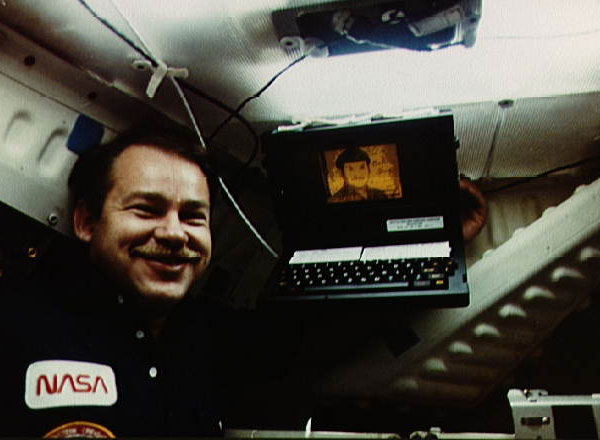 Astronaut John O. Creighton poses with onboard GRiD Compass computer, displaying a likeness of Mr. Spock of Star Trek, aboard Space Shuttle Discovery mission STS-51-G on 18 June 1985. 